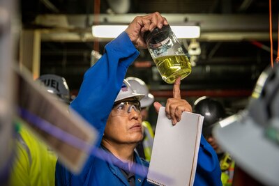 Quality Assurance representative with Joint Task Force-Red Hill (JTF-RH), Bo Cadiz, inspects a sample of fuel during dewatering at the Red Hill Bulk Fuel Storage Facility (RHBFSF) in Halawa, Hawaii, April 17, 2022. Dewatering is a critical step prior to defueling the RHBFSF. Dewatering removes the water from the fuel storage tanks. This is a routine task for maintenance of underground fuel storage tanks and is essential to prevent corrosion and protect fuel quality. Regulators from the Hawaii Department of Health and the Environmental Protection Agency are on site during dewatering. JTF-RH is committed to working with regulators, government officials, and stakeholders to ensure Red Hill is defueled safely, expeditiously and in compliance with all applicable laws and regulations. (U.S. Army photo by Spc. Matthew Mackintosh)