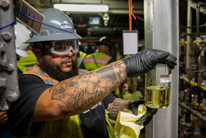 A fuel operator with Joint Task Force-Red Hill (JTF-RH) inspects a sample of fuel during dewatering at the Red Hill Bulk Fuel Storage Facility (RHBFSF) in Halawa, Hawaii, April 17, 2022. Dewatering is a critical step prior to defueling the RHBFSF. Dewatering removes the water from the fuel storage tanks. This is a routine task for maintenance of underground fuel storage tanks and is essential to prevent corrosion and protect fuel quality. Regulators from the Hawaii Department of Health and the Environmental Protection Agency are on site during dewatering. JTF-RH is committed to working with regulators, government officials, and stakeholders to ensure Red Hill is defueled safely, expeditiously and in compliance with all applicable laws and regulations.(U.S. Army photo by Spc. Matthew Mackintosh)
