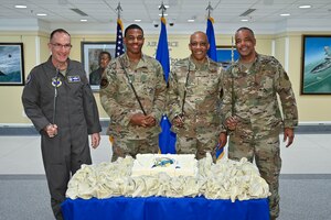 picture of Chief of Air Force Reserve Lt. Gen. John Healy, left, Senior Airman Shamadre Chambliss, the youngest airman present, Air Force Chief of Staff Gen. CQ Brown, Jr. and Chief Master Sgt. Tim White, command chief of Air Force Reserve Command, posing after cutting the cake