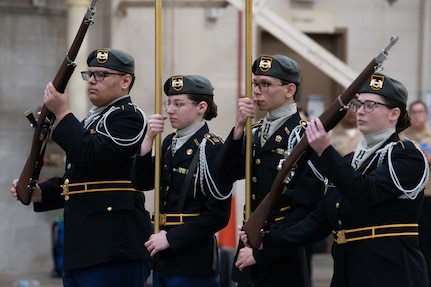 a junior rotc drill team demonstrates color guard skills during a competition