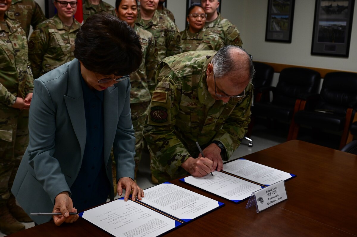 Ms. Sung Nak Yong (left), Gunsan Public Health head, and Dr. (Col.) Rene “Hawk” Saenz (right), 8th Medical Group commander, signs a memorandum of understanding (MoU) at Kunsan Air Base, Republic of Korea, Mar. 30, 2023.