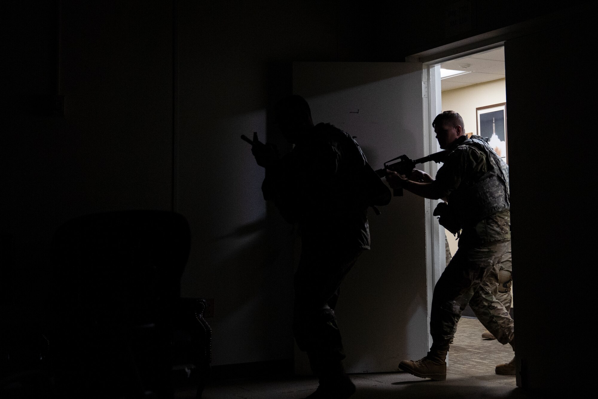 Members of the 85th Engineering Installation Squadron clear a room using close quarter battle tactics during MOB school at Keesler Air Force Base, Mississippi, April 12, 2023. In this course 85th EIS students learn weapons familiarization, combatives and other pre-deployment tactics.
