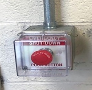 Picture shows a red emergency shut down button in a plastic case.