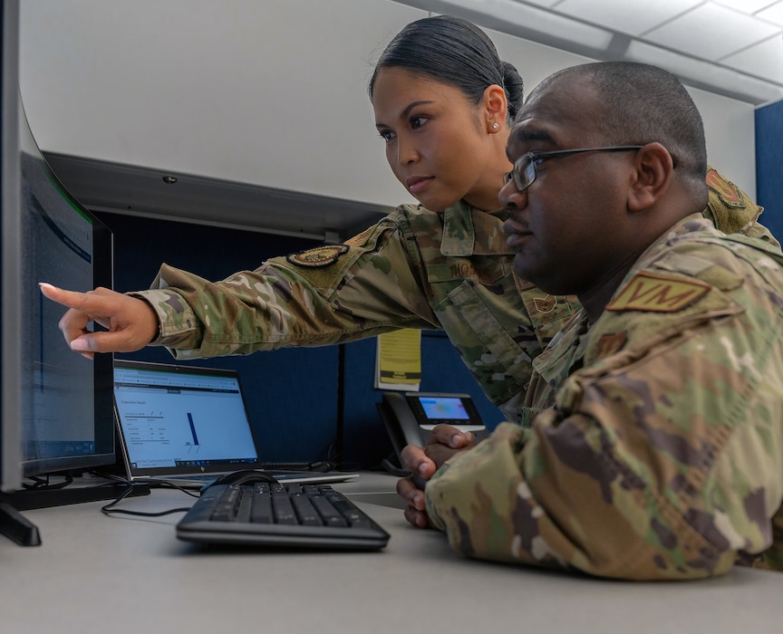 U.S. Air Force Tech. Sgt. Jennifer Gloria “JT” Thomas, 441st Vehicle Support Chain Operations Squadron, noncommissioned officer in charge of vehicle disposition and lease management, assists U.S. Air Force Staff Sgt. Miguel Graham