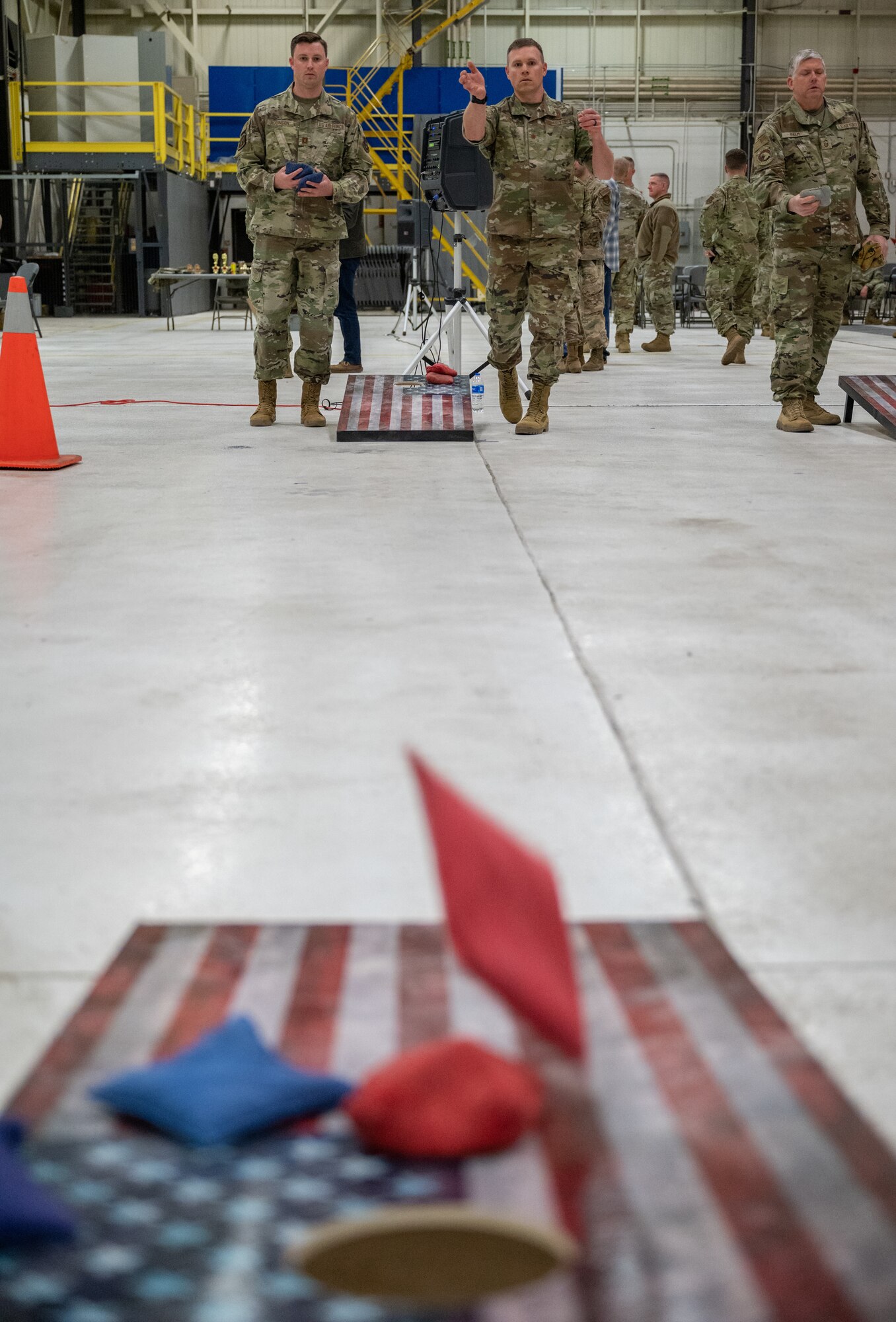 Two individuals playing corn-hole.