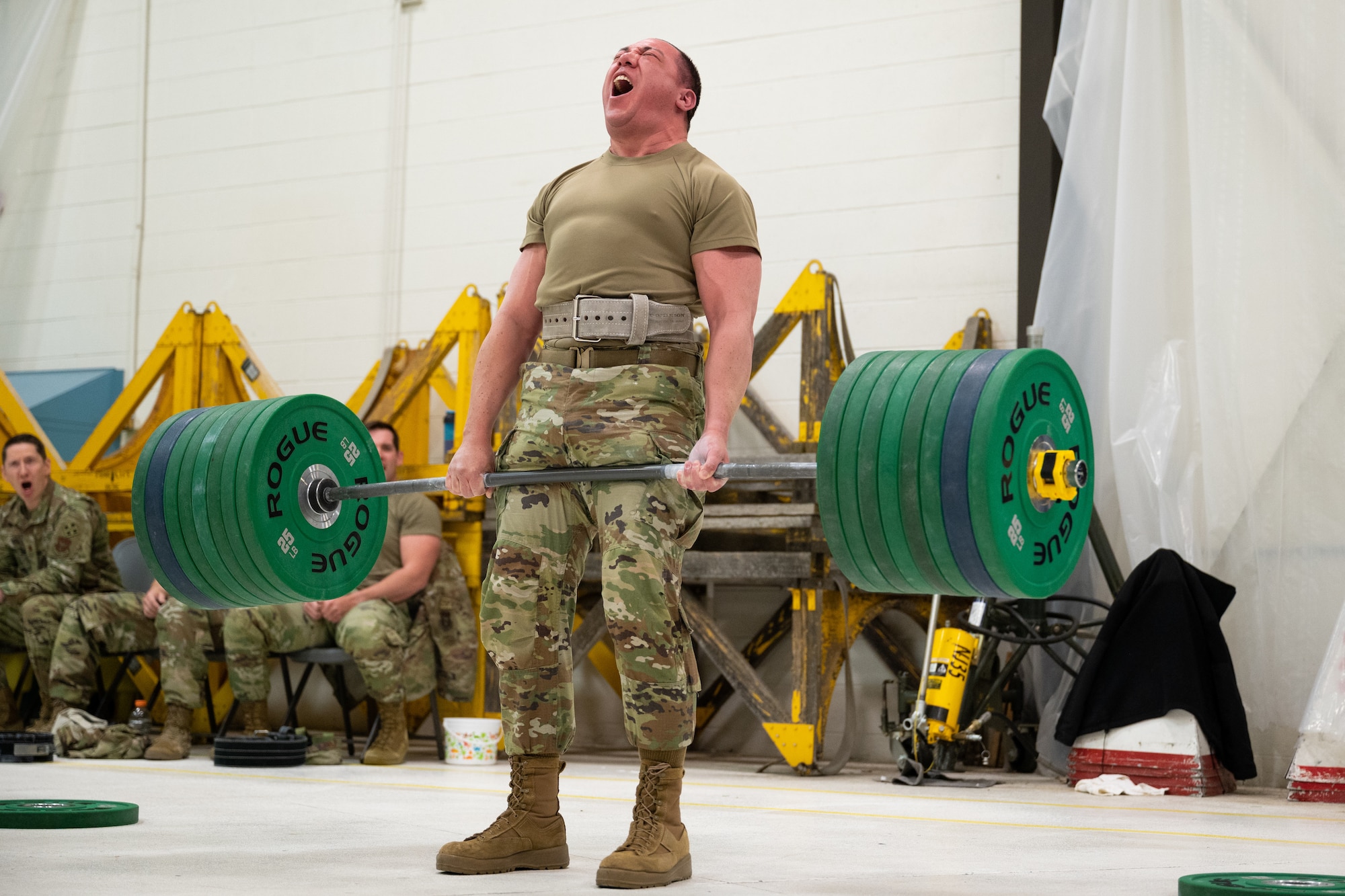 A man dead-lifting a barbell loaded with weight.
