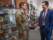 Congressman and military commander have a conversation inside a conference room with glass showcases filled with travel mementos