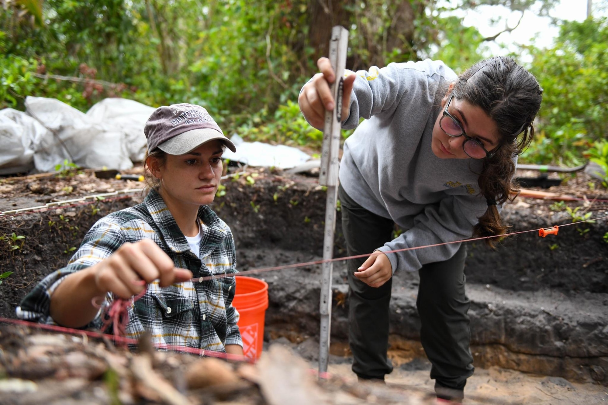 Melanie Ianggle and Cassie Hausdorf, Department of Anthropology students at University of Central Florida, use a line level to measure a surface level on April 12, 2023, at Cape Canaveral Space Force Station, Fla. Measuring surface levels allow archeologists to determine the
approximate time period they are excavating at. (U.S. Space Force photo by Senior Airman Samuel Becker)