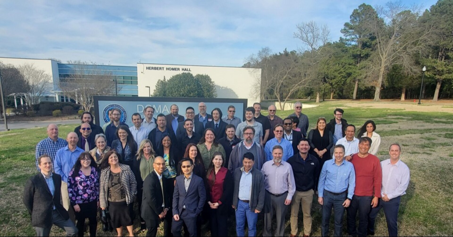 Attendees of the Earned Value Management Center offsite event held last month stand in front of the Defense Contract Management Agency headquarters building in Fort Lee, Virginia. Approximately 80 DCMA employees gathered at the agency headquarters, or attended the event virtually.