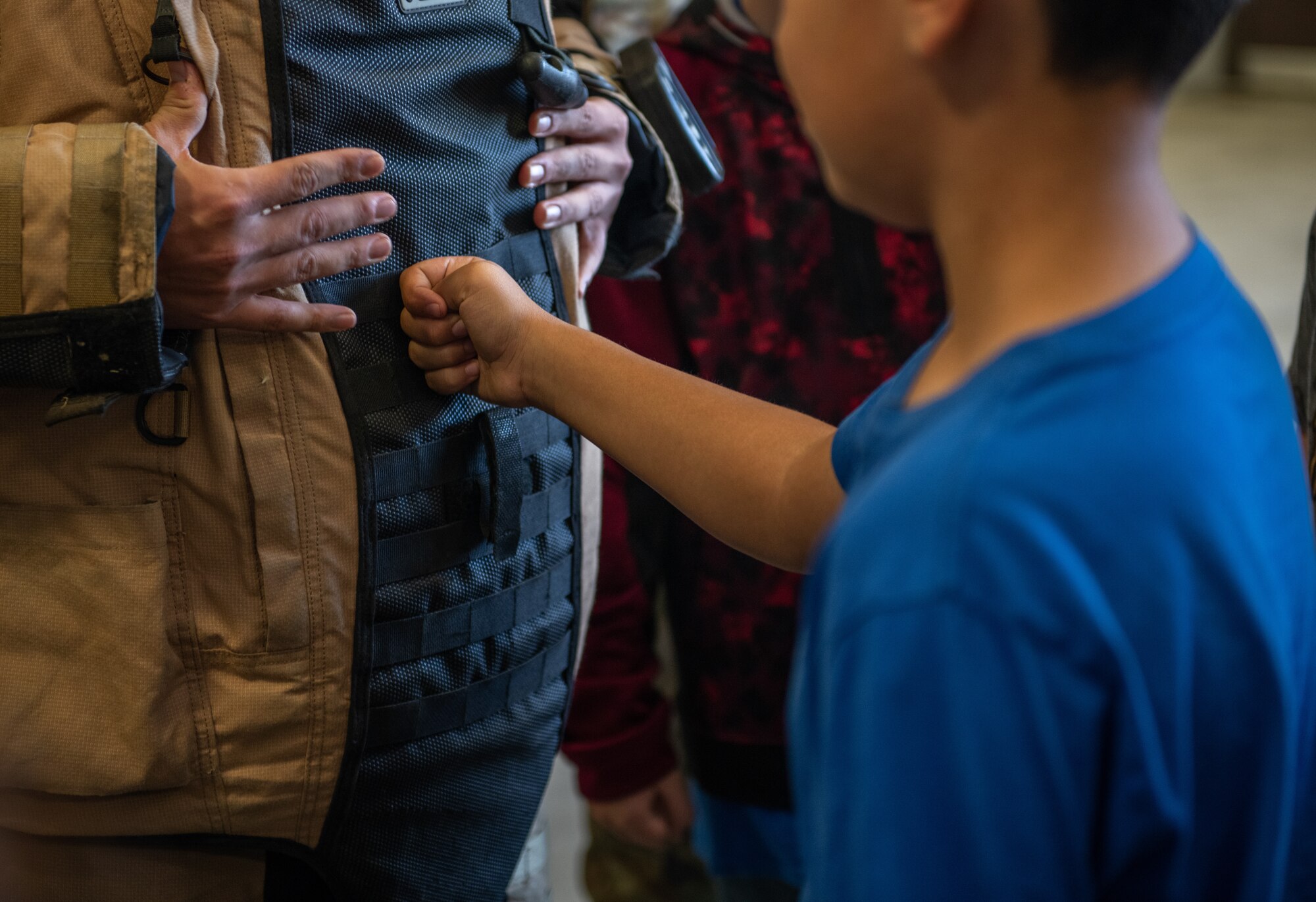 A child touches a bomb suit