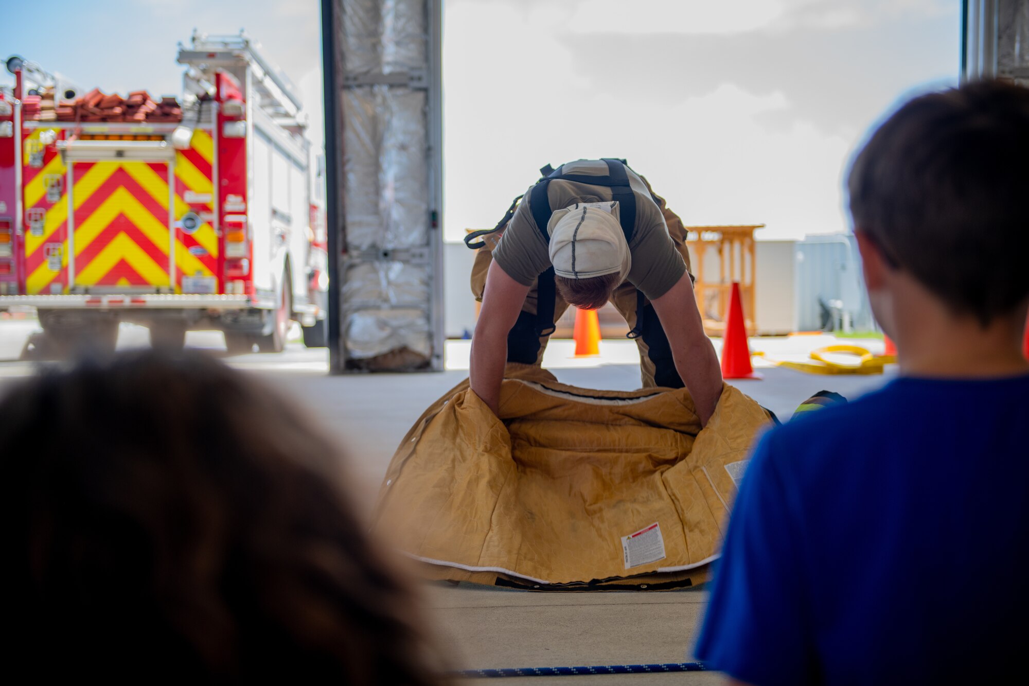 An airmen puts on fire fighter gear