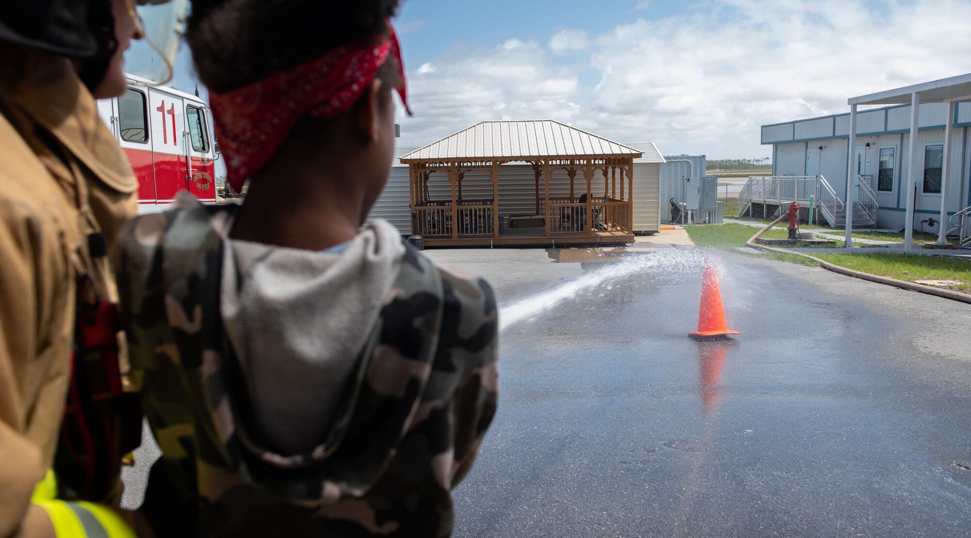 A child utilizes a fire hose under supervision