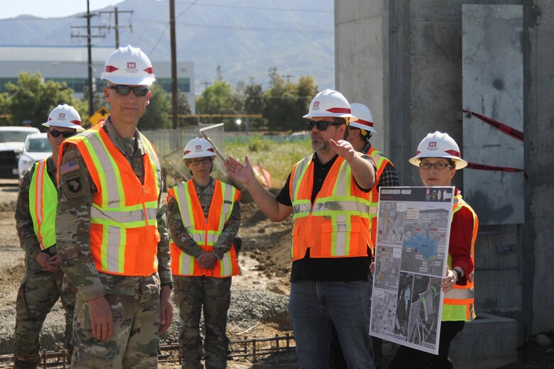 Col. Andrew Baker, who is scheduled to assume the role of Los Angeles District commander in July, foreground left, listens as Derek Walker, Santa Ana River Mainstem project manager with the LA District, right of center, describes the work progress April 6 at Alcoa Dike in Corona, California.