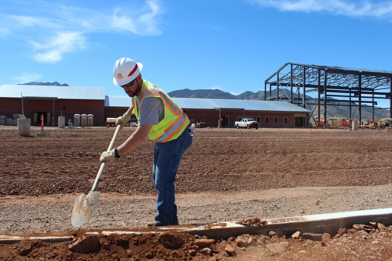 Contractor Thane Mir, a project manager with Rasch Construction Inc, removes sand and rocks from the curb before laying of pavement begins at the U.S. Army Corps of Engineers Los Angeles District’s Ground Transport Equipment project site March 14 near Sierra Vista, Arizona. Mir graduated from Colorado State University with a degree in construction management.