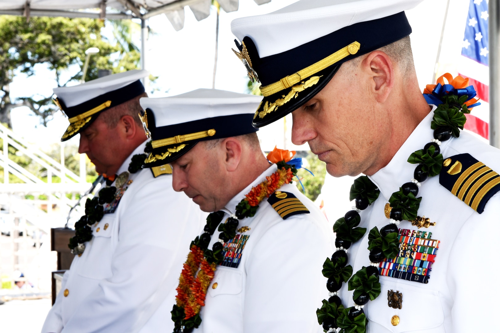 Capt. Brian Krautler, Capt. Stephen Adler and Rear Adm. Matthew Sibley (right to left) bow their heads in prayer during benediction at a change of command ceremony aboard the U.S. Coast Guard Cutter Stratton (WMSL 752) at Base Honolulu, April 17, 2023. Krautler assumed command of the Stratton, continuing his more than 12 years of sea service. (U.S. Coast Guard photo by Petty Officer 2nd Class Michael Clark)