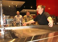 Tresser leans over ventless griddle