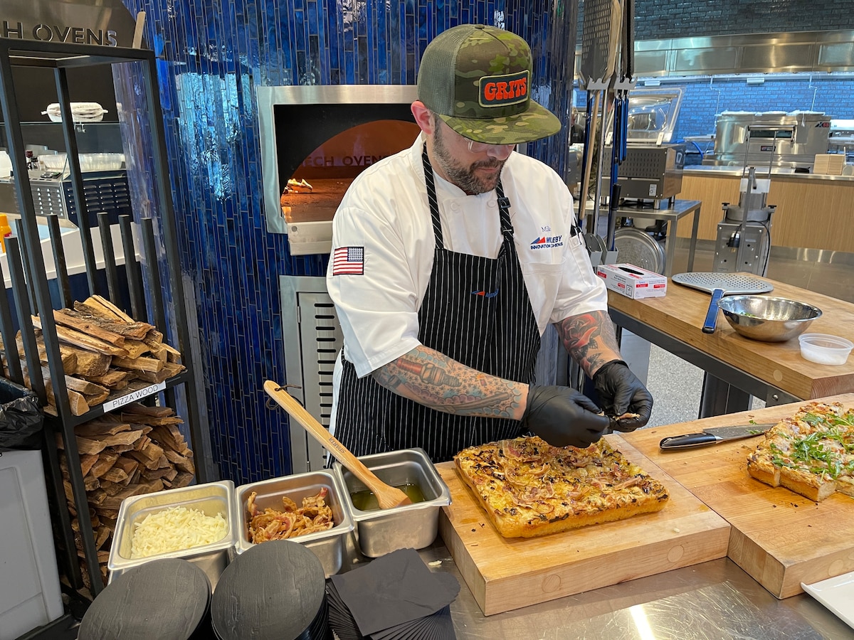Chef adds greens to the top of focaccia bread