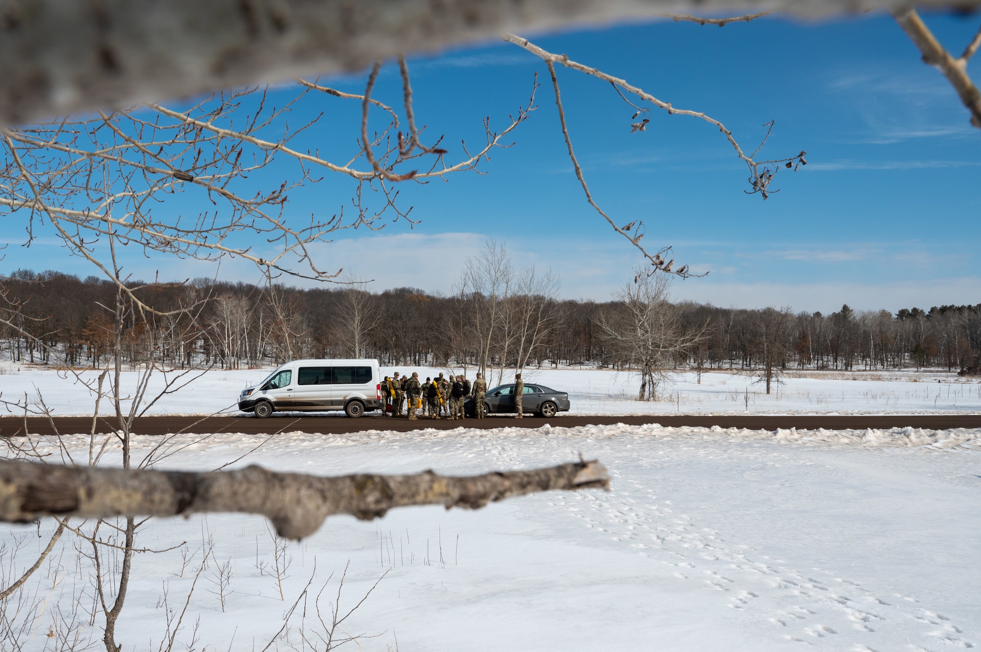 934th Civil Engineering Squadron Airmen huddle on the road at Camp Ripley, Minnesota, on April 2, 2023. The 934 CES conducted a field training exercise, including land navigation and general tent setup. (U.S. Air Force photo by Senior Airman Matthew Reisdorf)