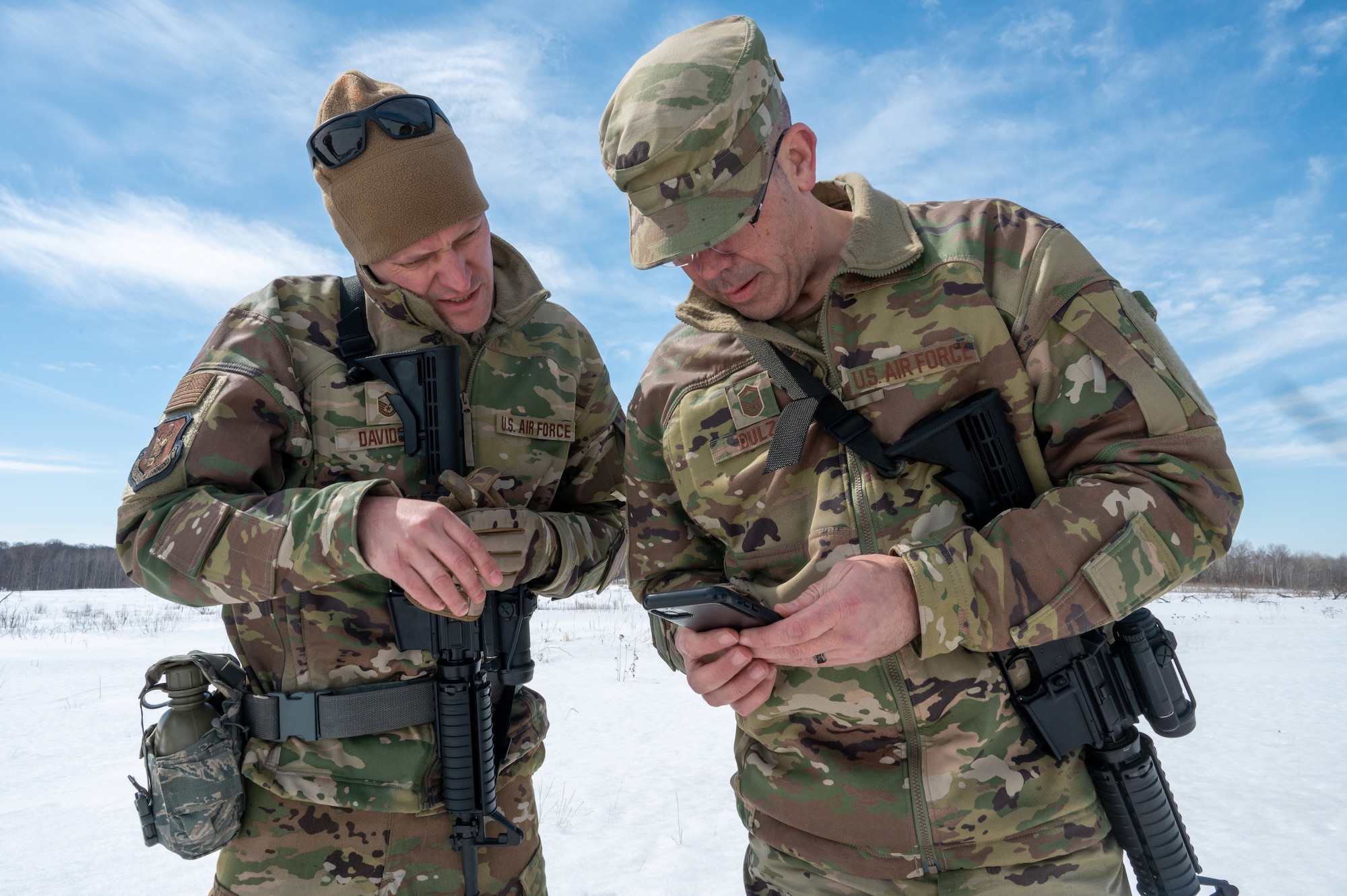 Master Sgt. Jonathan Davidson, a 934th Civil Engineering Squadron firefighter, and U.S. Senior Master Sgt. Patrick Dulzo, the 934 CES First Sgt., right, check their position via GPS during a land navigation course at Camp Ripley, Minnesota, on April 2, 2023. The 934 CES conducted a field training exercise, including land navigation and general tent setup (U.S. Air Force photo by Senior Airman Matthew Reisdorf)