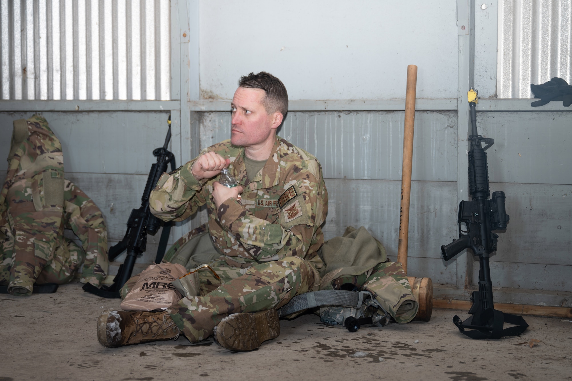 Master Sgt. Jonathan Davidson, a 934th Civil Engineering Squadron firefighter, takes a break after several hours of strenuous marching during a field exercise at Camp Ripley, Minnesota, on April 2, 2023. The 934 CES conducted a field training exercise, including land navigation and general tent setup. (U.S. Air Force photo by Senior Airman Matthew Reisdorf)