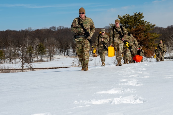 9934th Civil Engineering Squadron Airmen walk up a hill at Camp Ripley, Minnesota, on April 2, 2023. The 934 CES conducted a field training exercise, including land navigation and general tent setup. (U.S. Air Force photo by Senior Airman Matthew Reisdorf)