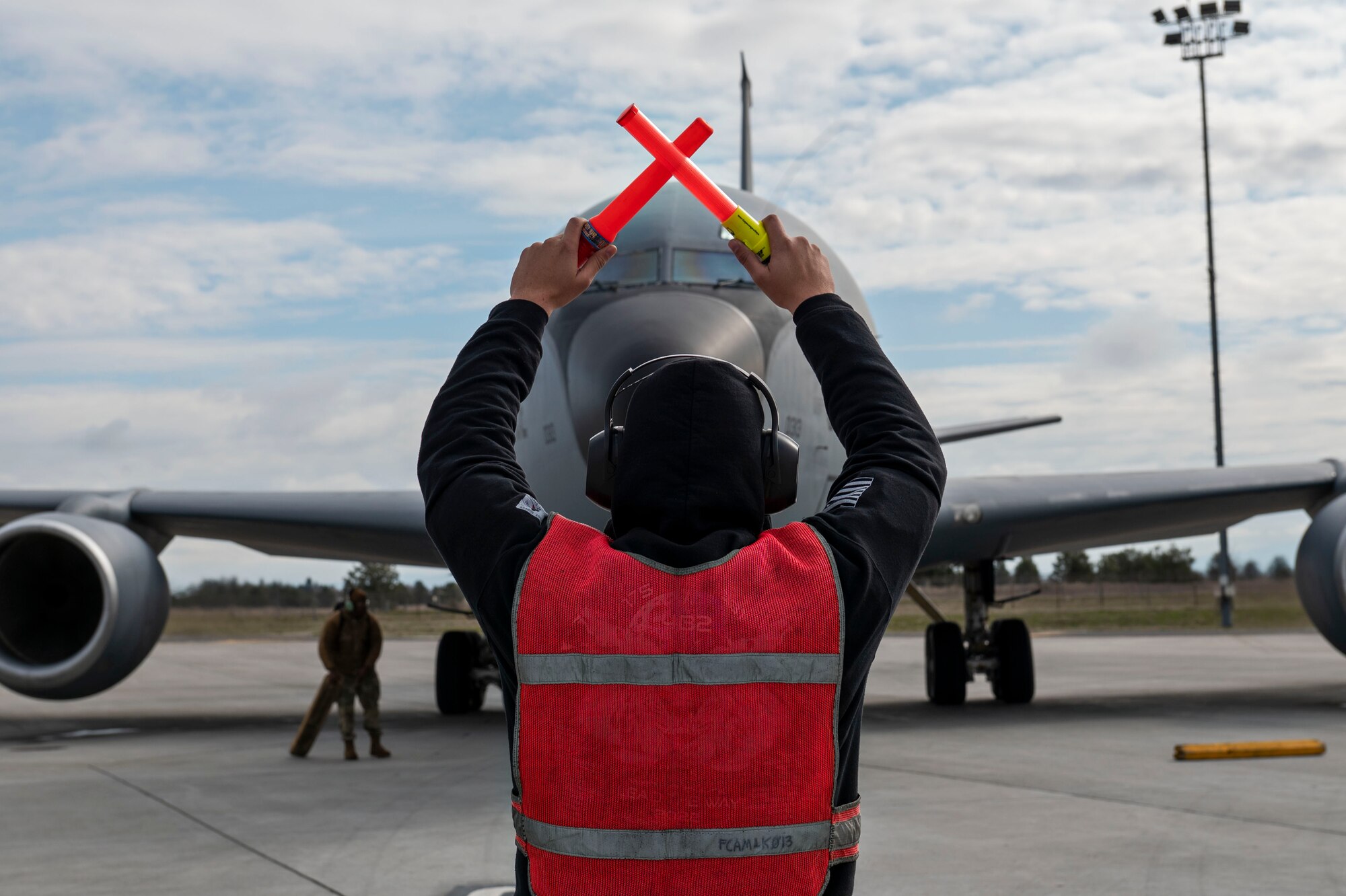 A U.S. Air Force Airman, assigned to Fairchild Air Force Base, marshals a KC-135 Stratotanker during exercise Global Thunder 23 at Fairchild Air Force Base, Washington, April 11, 2023. Exercises like Global Thunder involve extensive planning and coordination to provide unique training opportunities for assigned units and forces. (U.S. Air Force photo by Airman 1st Class Morgan Dailey)