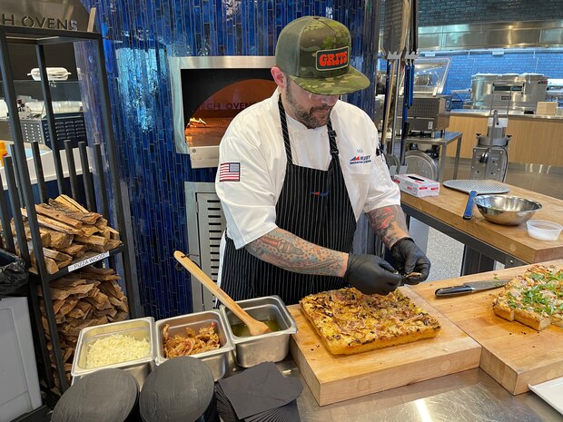 Chef adds greens to the top of focaccia bread