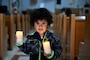 230417-N-XS877-7572 NAVAL SUPPORT ACTIVITY NAPLES, Italy (April 17, 2023) A child holds two candles meant to honor those who survived sexual assault during a candle lighting service onboard Naval Support Activity Naples’ (NSA) Support Site, April 17, 2023. NSA Naples is an operational ashore base that enables U.S., allied, and partner nation forces to be where they are needed, when they are needed to ensure security and stability in Europe, Africa, and Southwest Asia. (U.S. Navy photo by Aaliyah Essex)