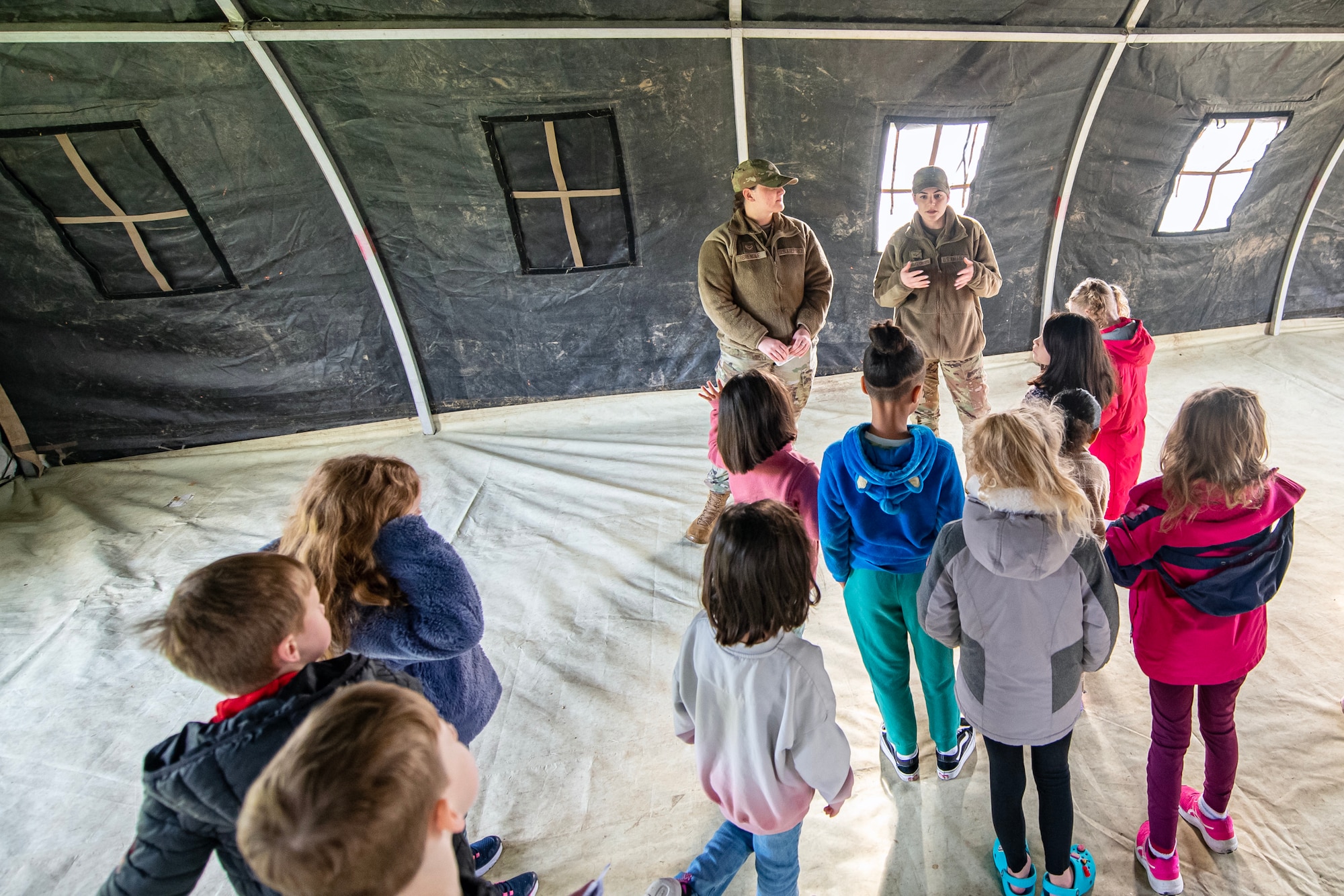 Airmen from the 423d Force Support Squadron, brief Alconbury Elementary school students during Camp Kudos at RAF Alconbury, England, April 14, 2023. The camp gave students the opportunity to experience and learn about various aspects of deployment preparation and the wing mission. (U.S. Air Force photo by Staff Sgt. Eugene Oliver)
