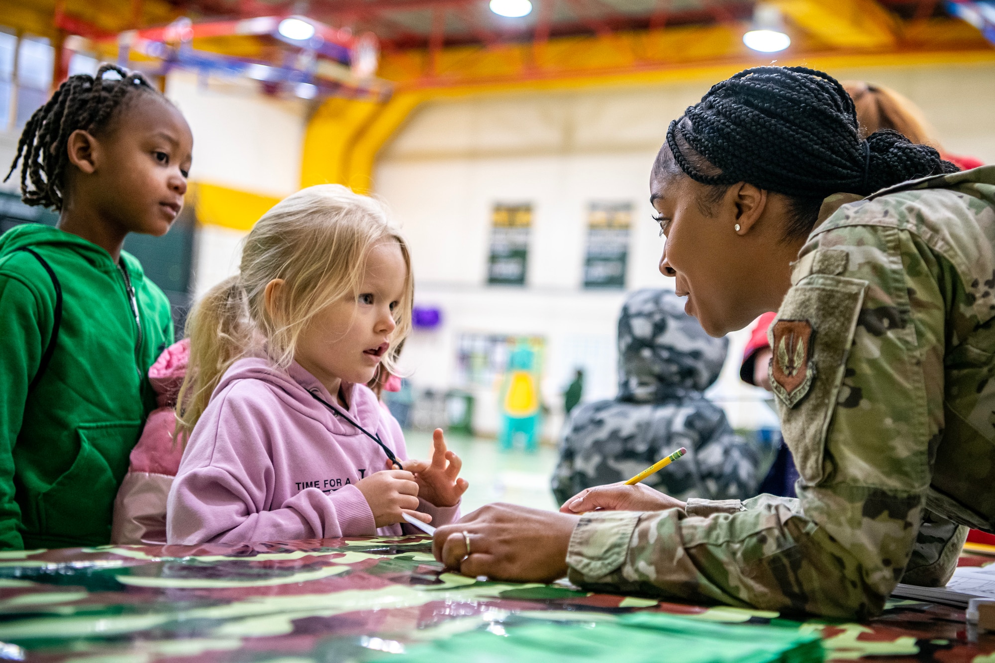 U.S. Air Force Senior Airman Takeira Ayala, 501st Combat Support Wing financial operations technician, speaks with a Alconbury Elementary School student during Camp Kudos at RAF Alconbury, England, April 14, 2023. The camp gave students the opportunity to experience and learn about various aspects of deployment preparation and the wing mission. (U.S. Air Force photo by Staff Sgt. Eugene Oliver)