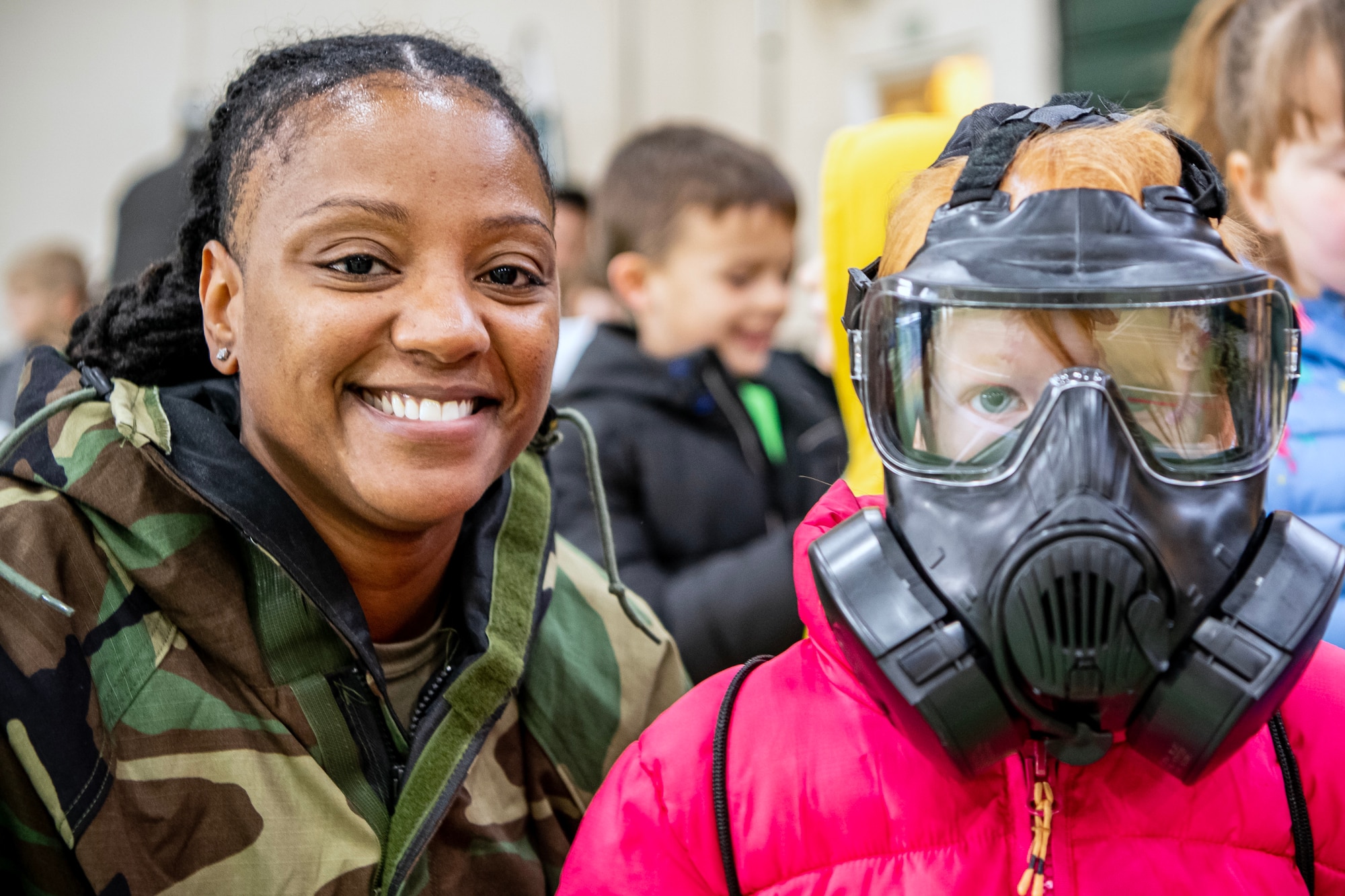 U.S. Air Force Staff Sgt. Akendra Brown, left, 423d Civil Engineer Squadron emergency management NCO in charge of training, poses for a photo with a Alconbury Elementary School student during Camp Kudos at RAF Alconbury, England, April 14, 2023. The camp gave students the opportunity to experience and learn about various aspects of deployment preparation and the wing mission. (U.S. Air Force photo by Staff Sgt. Eugene Oliver)