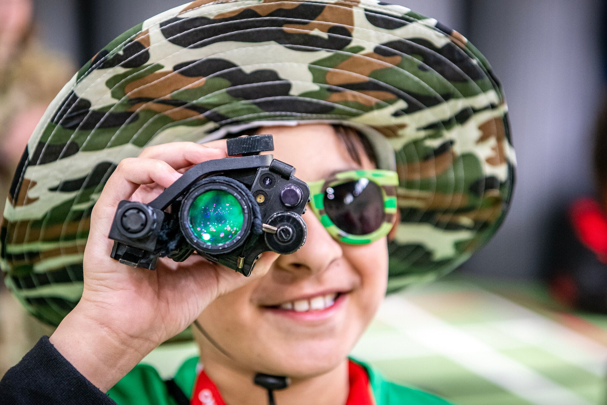 An Alconbury elementary school student looks through a rangefinder during Camp Kudos at RAF Alconbury, England, April 14, 2023. The camp gave students the opportunity to experience and learn about various aspects of deployment preparation and the wing mission. (U.S. Air Force photo by Staff Sgt. Eugene Oliver)
