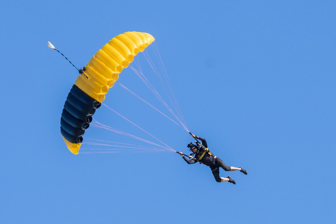 A soldier parachutes through the air.