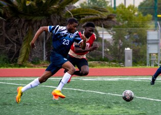 Seaman Jude Chukwuobasi, left, assigned to amphibious assault ship USS Essex (LHD 2), sprints after a ball during a soccer tournament at Admiral Prout Field onboard Naval Base San Diego, April 13.