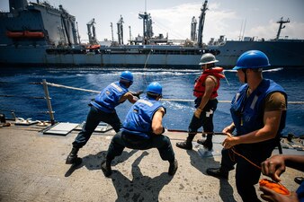 Sailors handle line aboard the Ticonderoga-class guided-missile cruiser USS Bunker Hill (CG 52) during a replenishment-at-sea with the Henry J. Kaiser-class fleet replenishment oiler USNS Tippecanoe (T-AO 199).