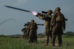 A person in military uniform fires missile.