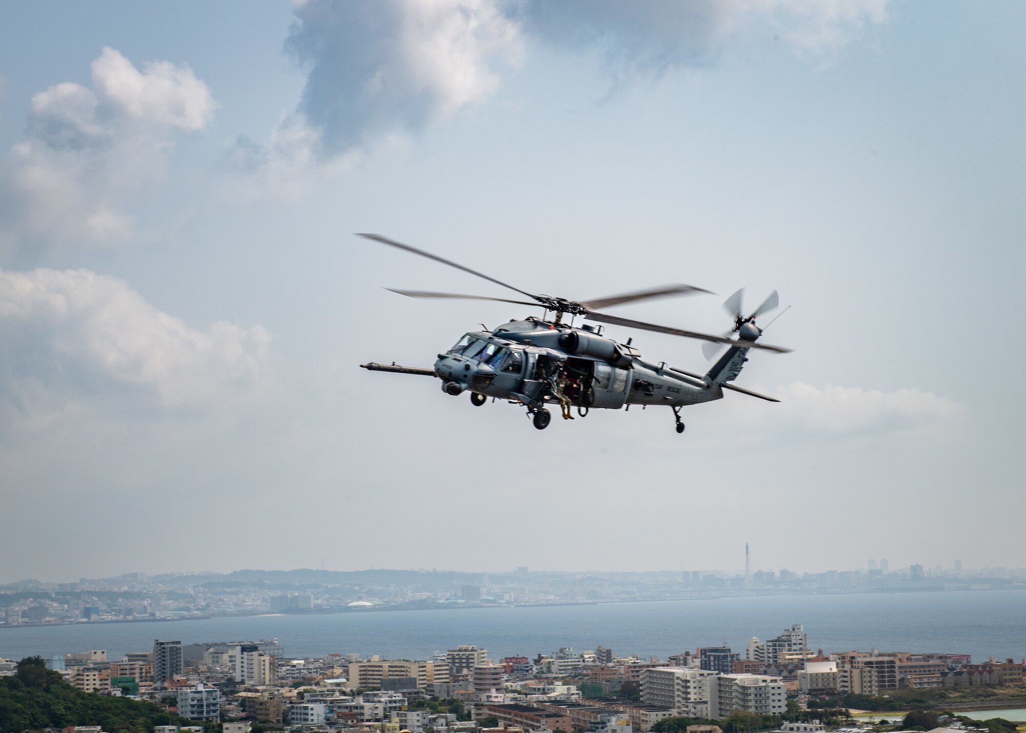 A helicopter flies over a cityscape.