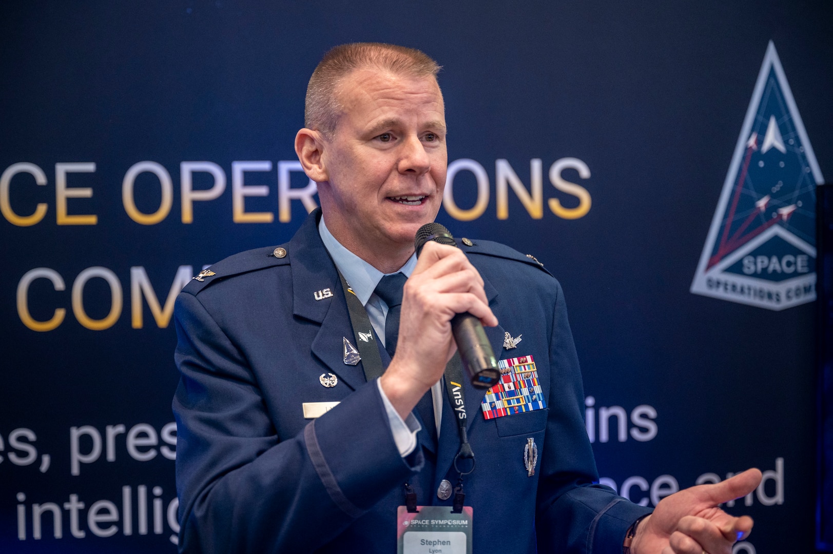 Man in uniform speaks into microphone