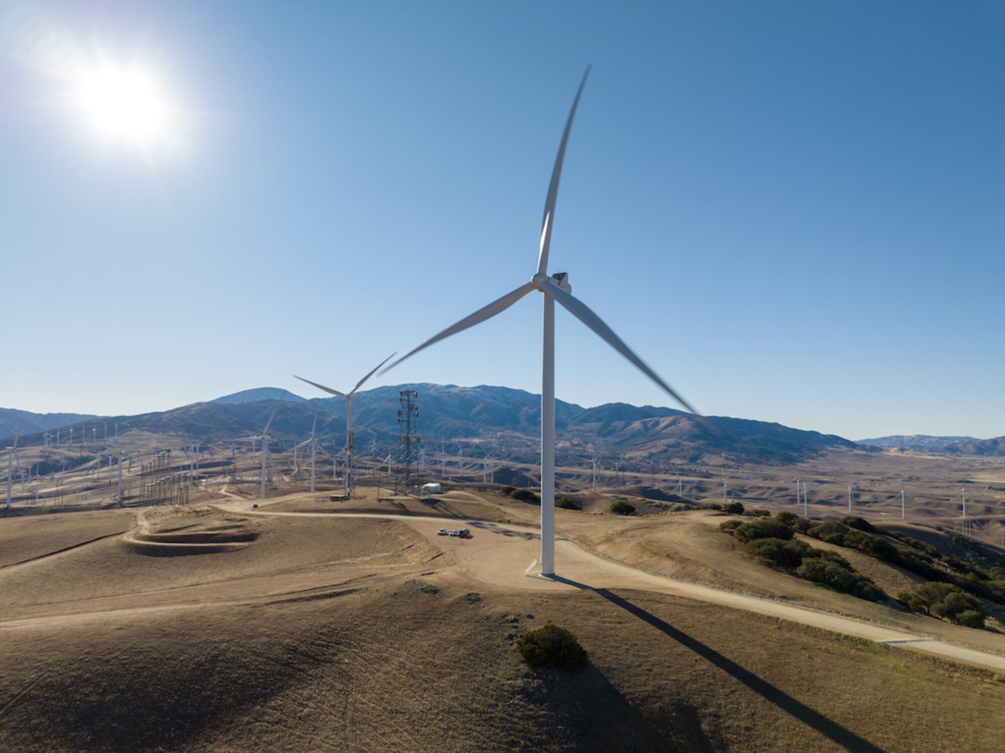 Wind turbine sits in the foreground at Edwards AFB in California flanked by California hillside.