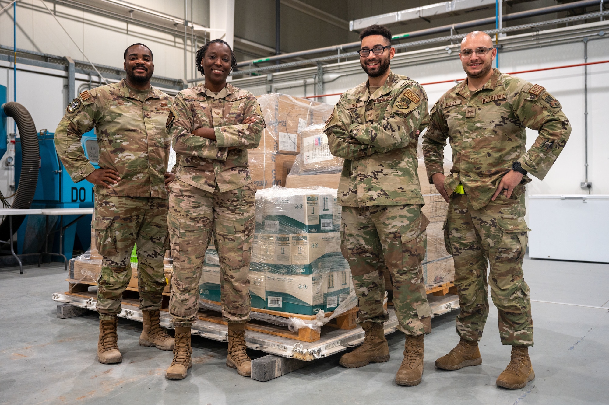 A photo of Airmen standing in front of humanitarian aid supplies