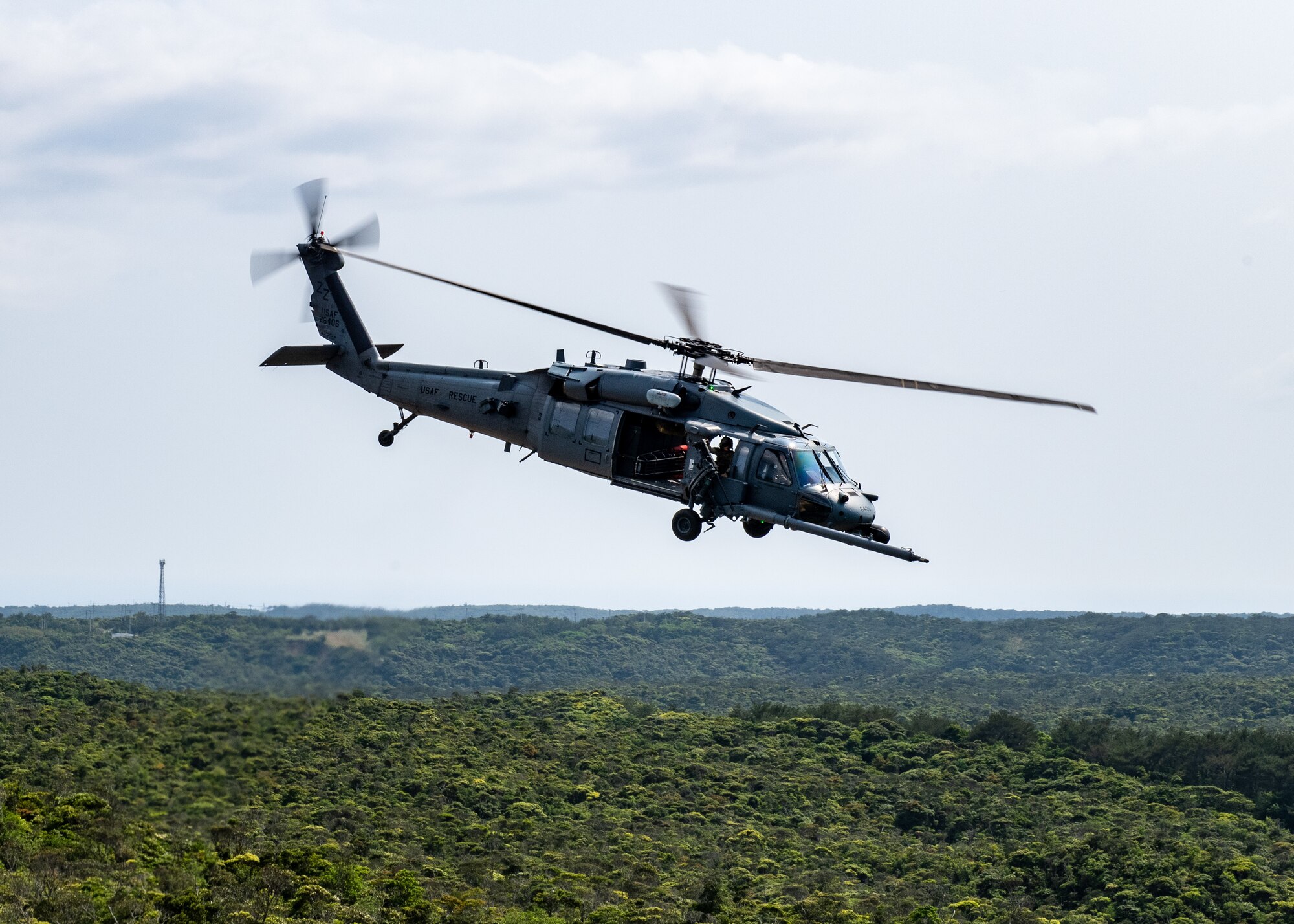 A helicopter flies over land.