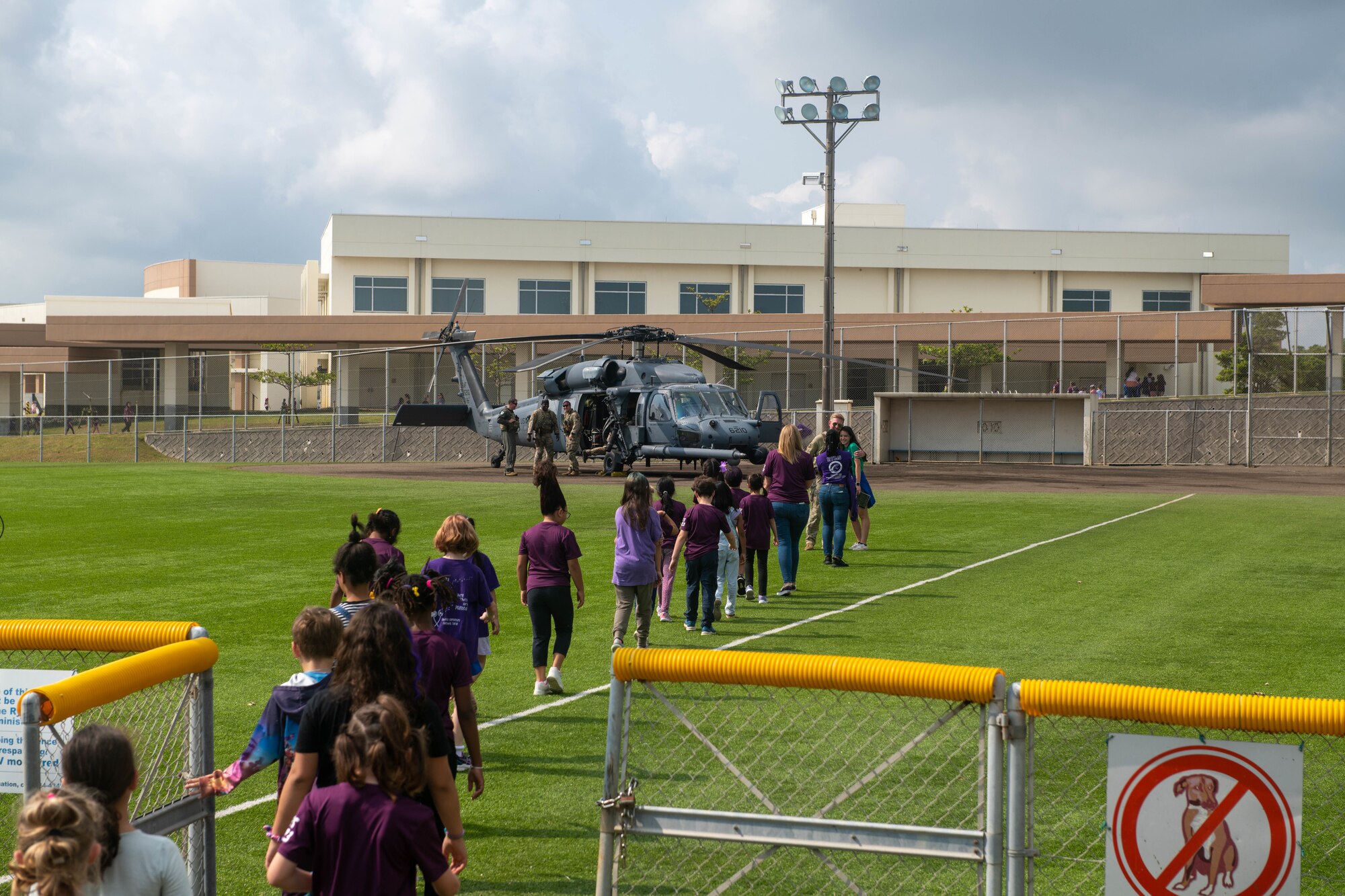 Kids walk to a helicopter.