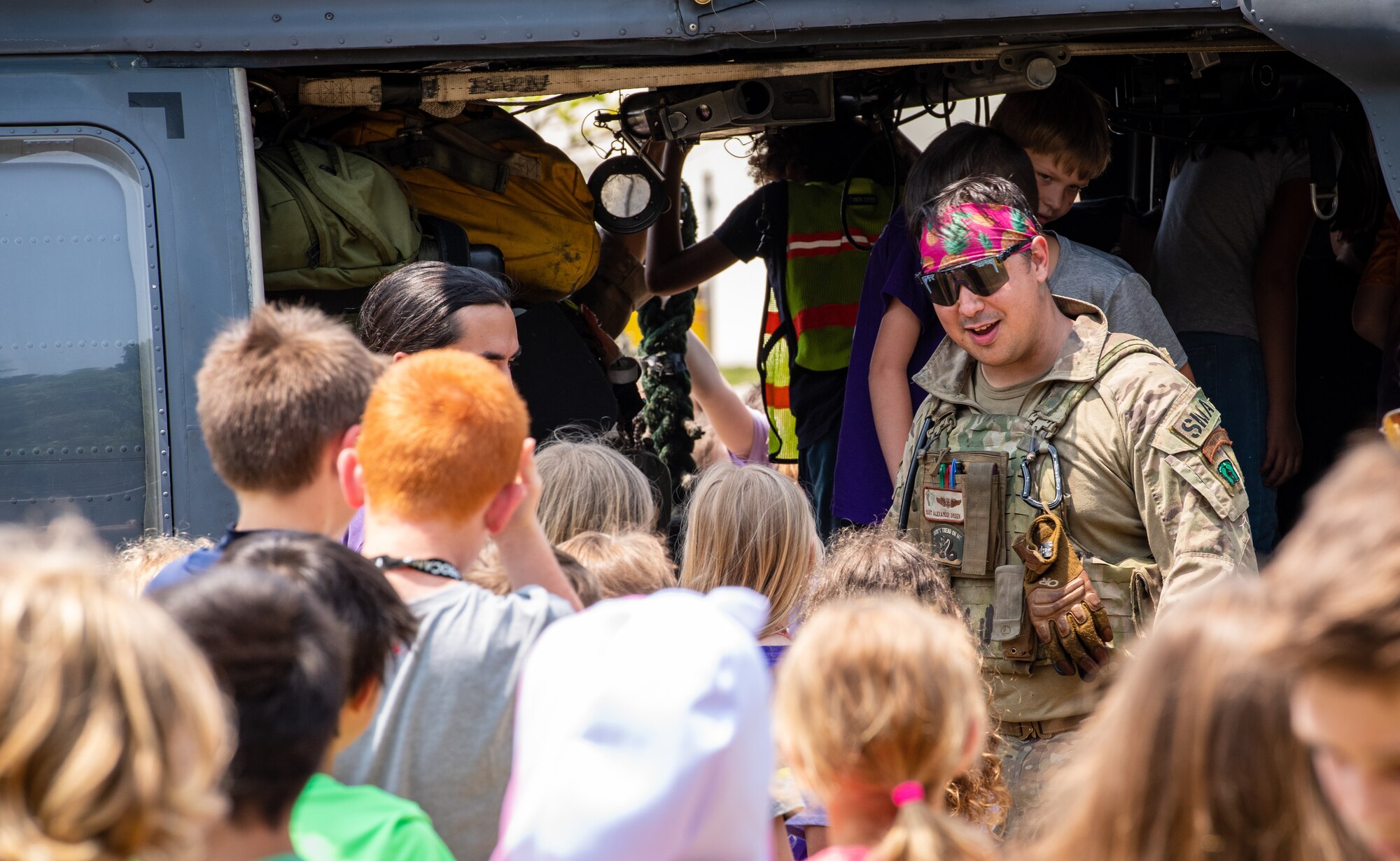 An Airman helps kids into a helicopter.