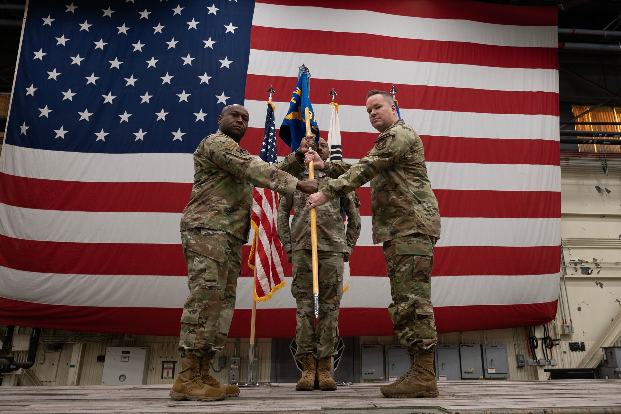 Col. Henry R. Jeffress III (left), 8th Fighter Wing commander, presents the ceremonial guidon to Col. Bradley Altman (right), incoming 8th Maintenance Group commander, during the 8th MXG assumption of command ceremony at Kunsan Air Base, Republic of Korea, Apr. 10, 2023.