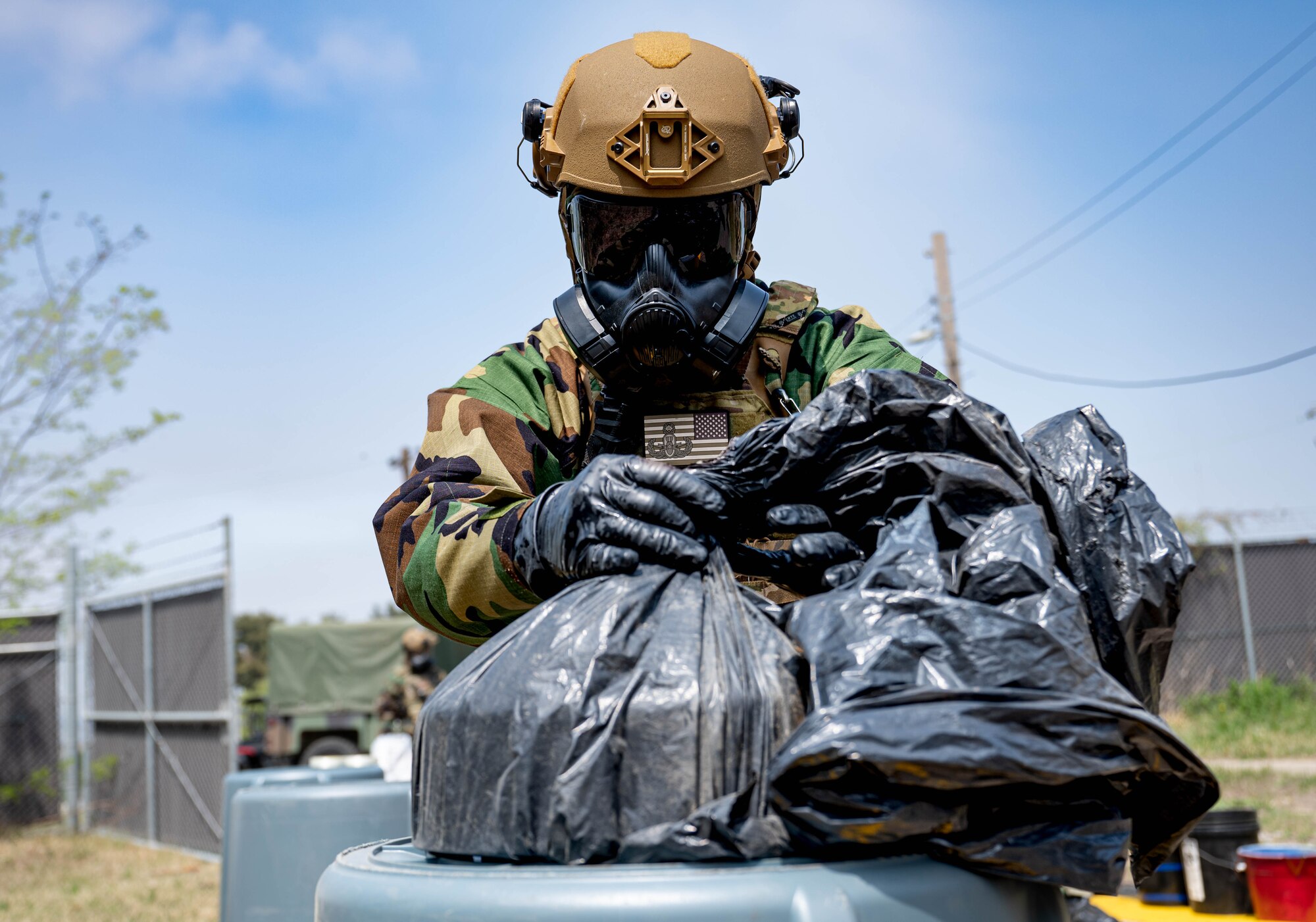 Senior Airman Charles James, 8th Civil Engineer Squadron explosive ordnance disposal technician, secures chemical ordnance in a plastic bag during a training event at Kunsan Air Base, Republic of Korea, April 20, 2023. EOD members were tasked with mitigating hazards from leaking chemical munitions. (U.S. Air Force photo illustration by Senior Airman Shannon Braaten)
