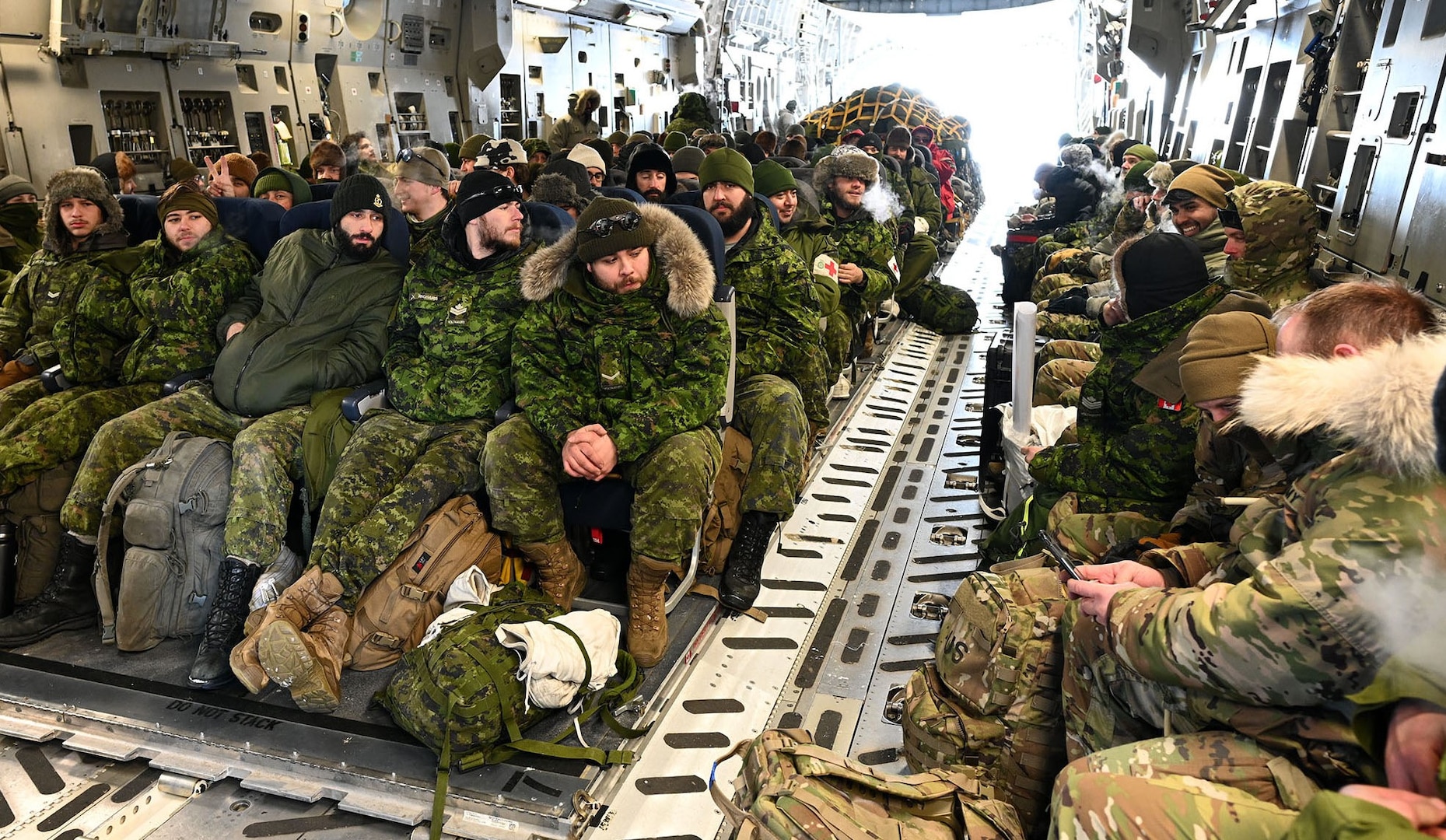 Canadian Army reserve and American National Guard Soldiers wait for takeoff in Resolute Bay, Nunavut, onboard a C-17 Globemaster III flown by the New York Air National Guard's 105th Airlift Wing March 18, 2023, during Exercise Guerrier Nordique. The Soldiers were briefed by two intelligence Airmen assigned to the New York Air Guard's 109th Airlift Wing before heading north to the Arctic.