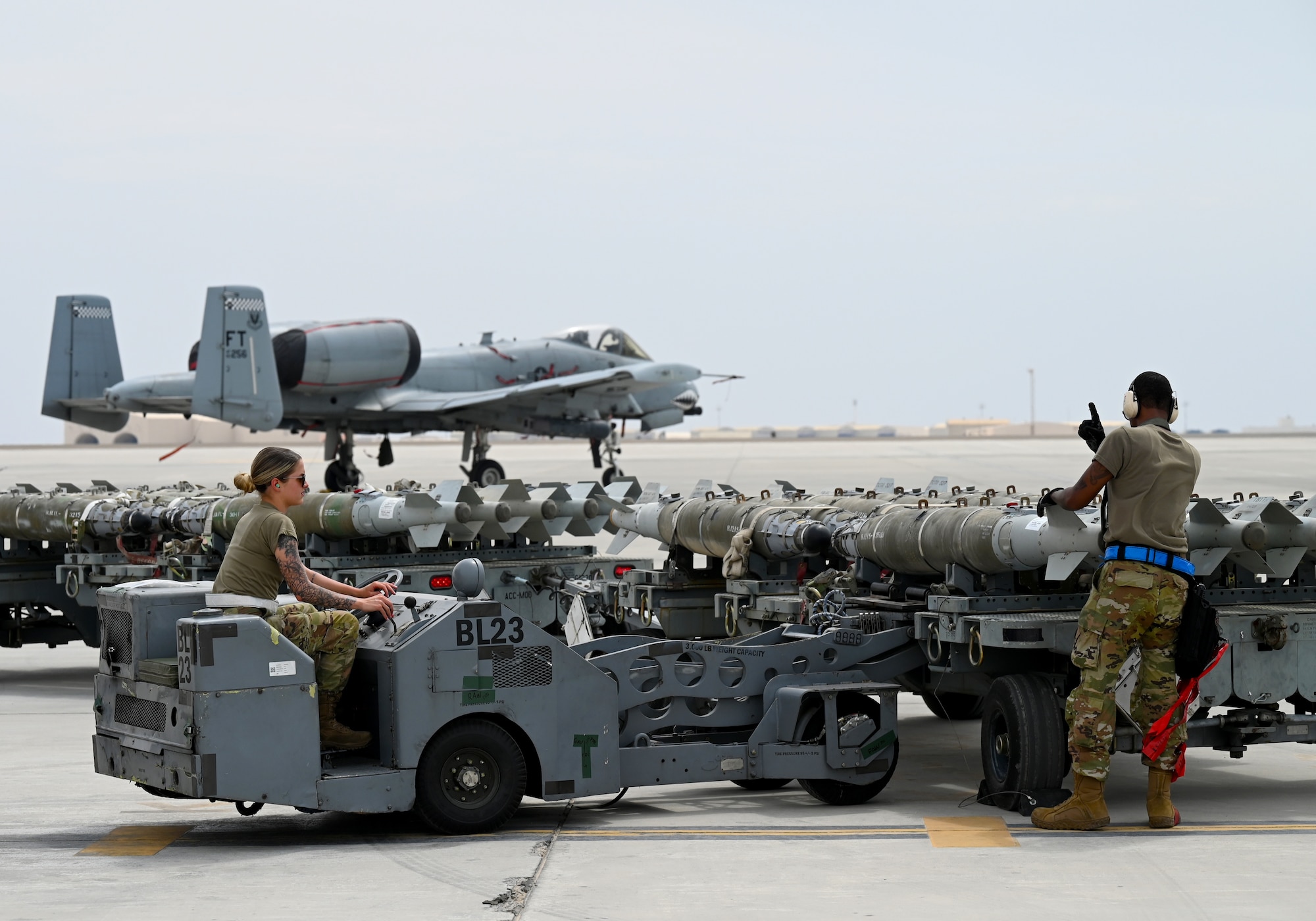 U.S. Air Force Staff Sgt. Brian Dorsey, right, 75th Expeditionary Fighter Generation Squadron lead crew chief, guides Senior Airman Reese Deandrea, 75th EFGS lead crew member, as she lifts munitions with a jammer at Al Dhafra Air Base, United Arab Emirates, April 18, 2022. The loading of these munitions represents another step forward in the deployment of the A-10 to the U.S. Central Command area of responsibility, which offers the opportunity for 9th Air Force (Air Forces Central). to experiment with CAS capabilities in order to achieve the most robust, diverse force possible. Ninth AF (AFCENT) is committed to ensuring security and stability alongside our partners in the U.S. Central Command area of responsibility. (U.S. Air Force photo by Tech. Sgt. Alex Fox Echols III)