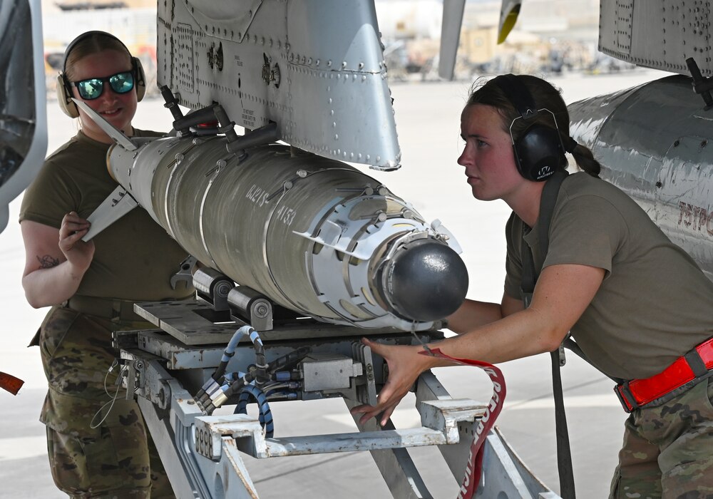 U.S. Air Force Staff Sgt. Journey Yanzick, right, and Senior Airman Sydney Olsen, 75th Expeditionary Fighter Generation Squadron weapons crew members, secure munitions onto a U.S. Air Force A-10 Thunderbolt II at Al Dhafra Air Base, United Arab Emirates, April 18, 2022. The loading of these munitions represents another step forward in the deployment of the A-10 to the U.S. Central Command area of responsibility, which offers the opportunity for 9th Air Force (Air Forces Central). to experiment with CAS capabilities in order to achieve the most robust, diverse force possible. Ninth AF (AFCENT) is committed to ensuring security and stability alongside our partners in the U.S. Central Command area of responsibility. (U.S. Air Force photo by Tech. Sgt. Alex Fox Echols III)