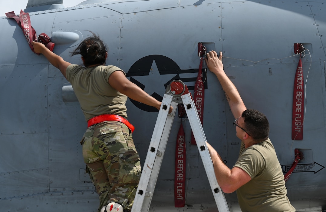 U.S. Air Force Airman 1st Class Serena Mena, 75th Expeditionary Fighter Generation Squadron weapons load crew member, and Senior Airman Nickolus Huscha, 74th Expeditionary Fighter Generation Squadron weapons load crew member, remove pins and coverings prior to loading ammunition into a U.S. Air Force A-10 Thunderbolt II at Al Dhafra Air Base, United Arab Emirates, April 18, 2022. The deployment of A-10s in the region provides additional capability in the Middle East alongside fighter aircraft. Ninth Air Force (U.S. Air Forces Central) is committed to ensuring security and stability alongside our partners in the U.S. Central Command area of responsibility. (U.S. Air Force photo by Tech. Sgt. Alex Fox Echols III)
