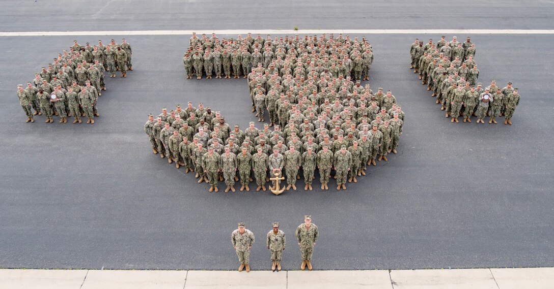 Naval Mobile Construction Battalion (NMCB) 3 posses in the shape of a three for a command photo, Mar. 16, 2023.